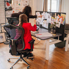 Bureau assis debout électrique avec panneau séparateur acoustique dans un espace de travail créatif
